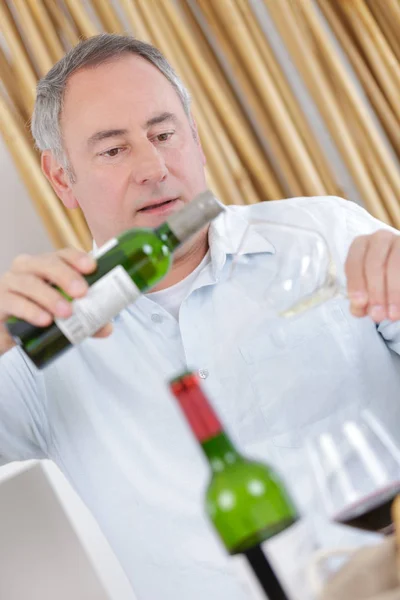Uomo versando dalla bottiglia di vino — Foto Stock