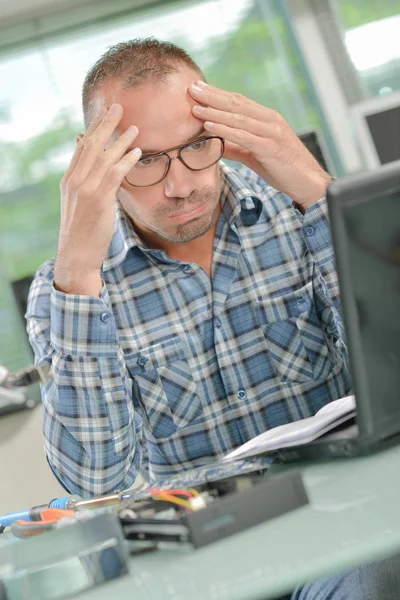 Homem de negócios preocupado na frente de seu laptop — Fotografia de Stock