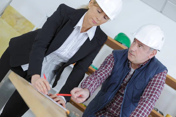 Female engineer talking with builder — Stock Photo, Image