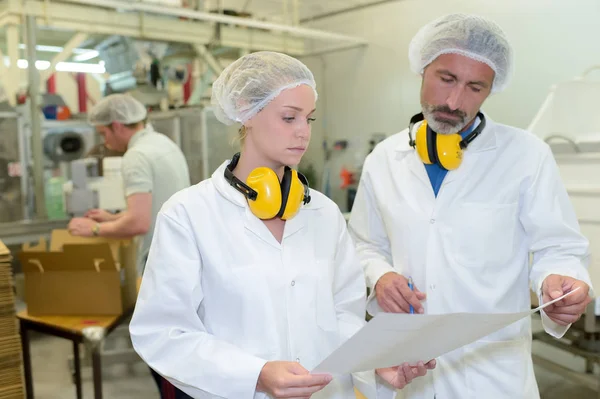 Serious factory workers and man — Stock Photo, Image