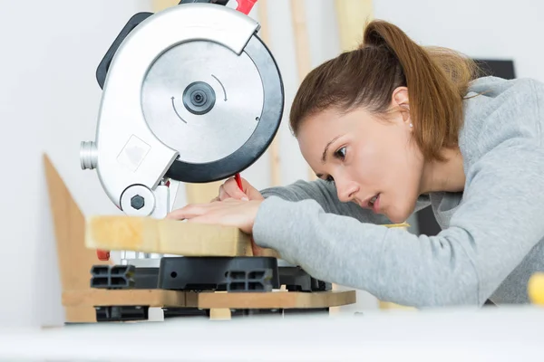 女性 arpenter は、円の鋸を使用しています。 — ストック写真