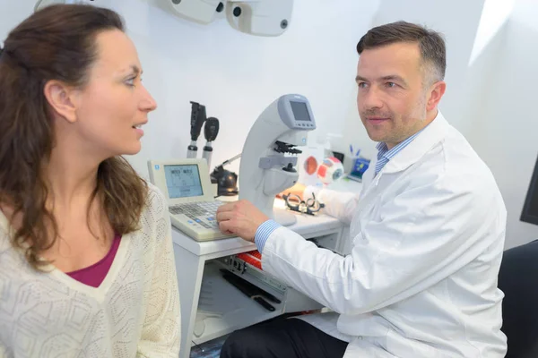 Kvinnlig patient interagerar med optiker i oftalmologi klinik — Stockfoto