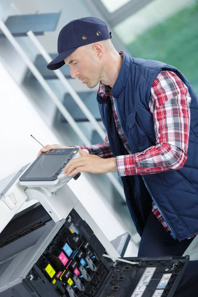 Druckertechniker repariert einen Drucker — Stockfoto