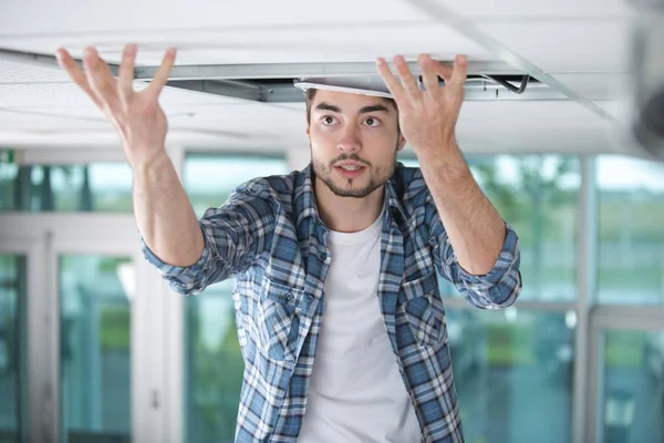 Builder replacing ceiling panel — Stock Photo, Image