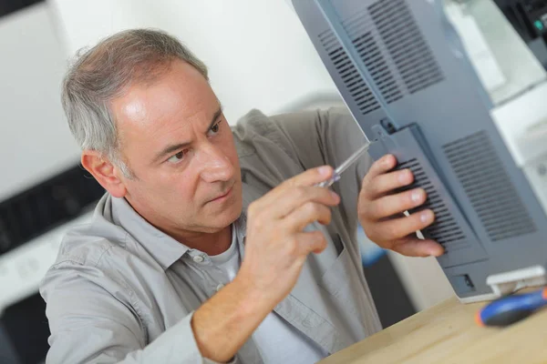 Manliga tekniker kontrollera maskinen med skruvmejsel — Stockfoto