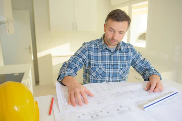 Architect looking at plan in construction site — Stock Photo, Image