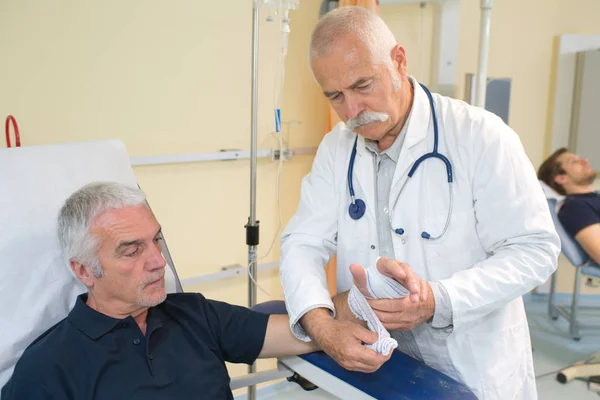 Dokter membungkus tangan pasien. — Stok Foto