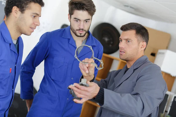 Jóvenes aprendices mecánicos en un taller — Foto de Stock