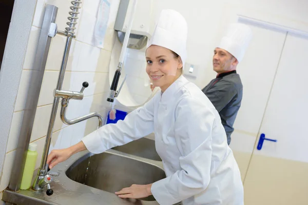 Köchin wäscht sich vor der Zubereitung die Hände — Stockfoto