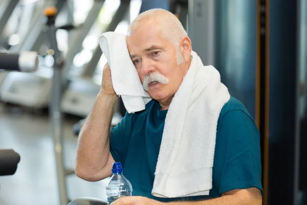 Ajuste homem sênior descansando depois de trabalhar para fora — Fotografia de Stock