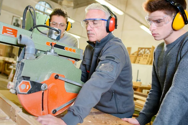 Étudiants apprenant à utiliser une grande scie circulaire — Photo