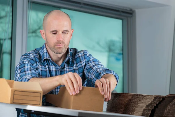 Portrait de jeune homme préparant des boîtes — Photo