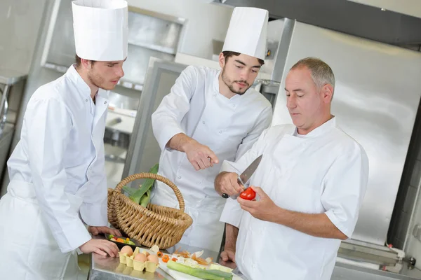 Chefkoch arbeitet mit seinen Assistenten — Stockfoto