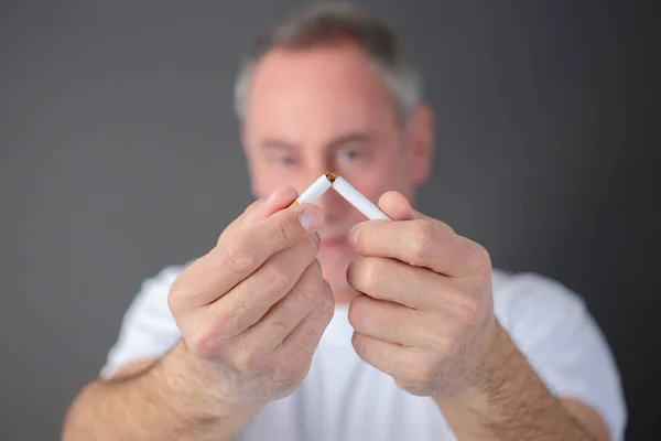 Homem adulto quebrando cigarro — Fotografia de Stock