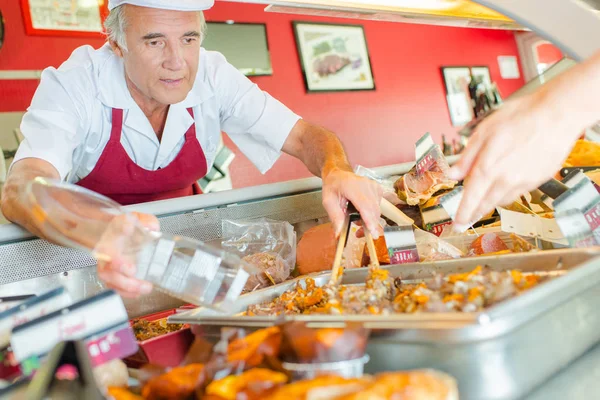 Butcher serving customer and apron — Stock Photo, Image