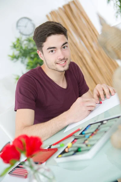 Jonge man tekening foto's in studio — Stockfoto