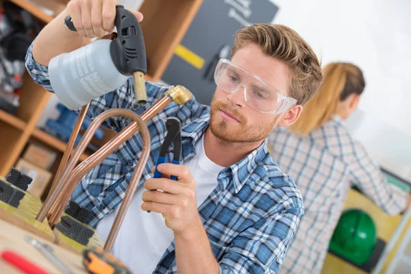 Trabajador usando soplete en tubo de cobre — Foto de Stock