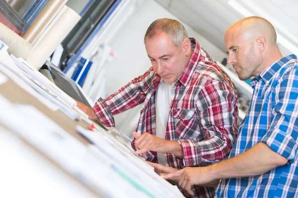 Lachende mensen uit het bedrijfsleven bespreken over papierwerk op kantoor — Stockfoto