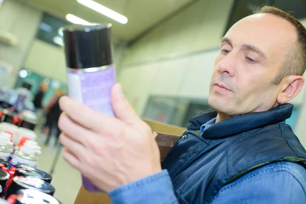 家庭用で昆虫のキラー スプレーを選択する陽気な男 — ストック写真