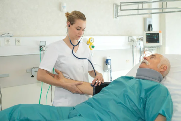 Enfermera haciendo un examen médico en paciente mayor — Foto de Stock