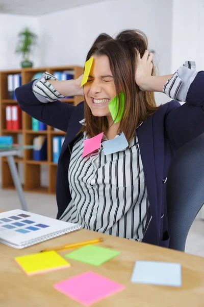 Geschäftsfrau mit Posen überall in ihrem Büro — Stockfoto