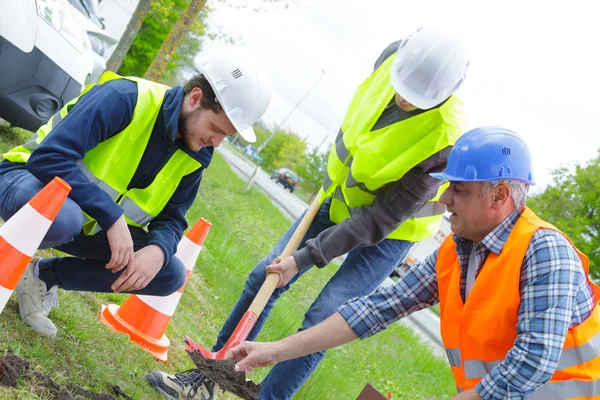 Arbetstagare bygga konkret gångväg i gröna fältet — Stockfoto