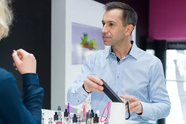 Male seller advising client in vape store — Stock Photo, Image