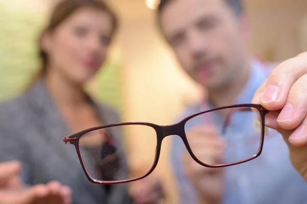 Lunettes à monture de fil mince mise au point étroite dans les mains opticiens — Photo