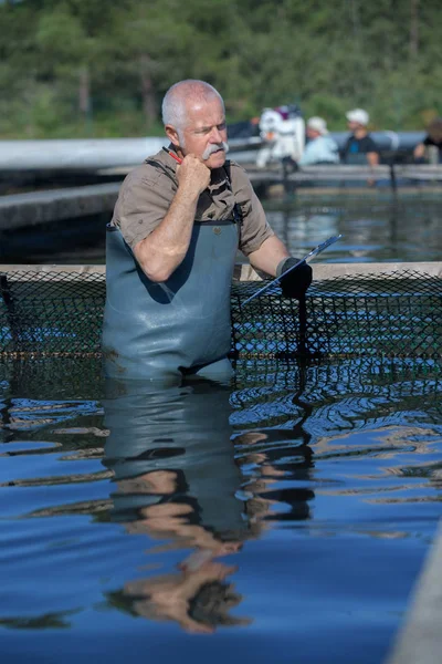 彼の魚の池の先輩起業家 — ストック写真