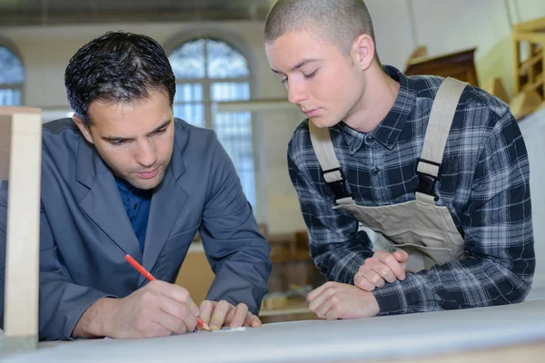 Falegname e apprendista che lavora con il legno — Foto Stock