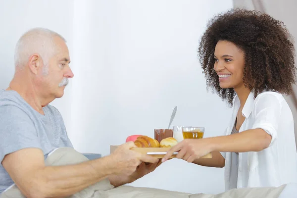 Anciano en casa de ancianos desayunando en la cama — Foto de Stock