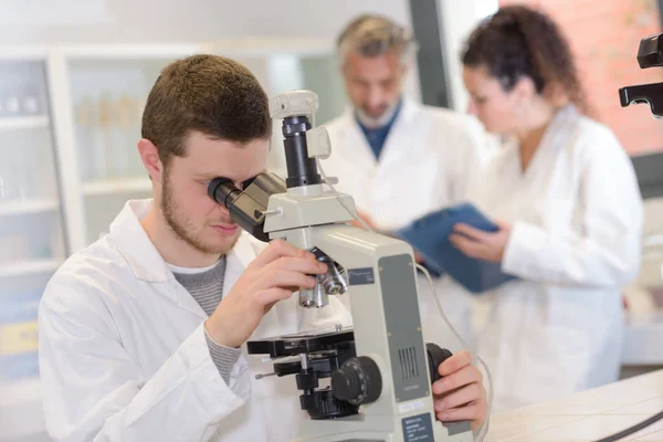 Ung Man Skyddande Glasögon Tittar Mikroskop Laboratorium — Stockfoto