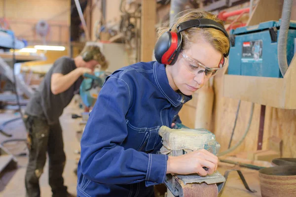 ワーク ショップにおける木材のサンダーを使用して女性の大工の中央部 — ストック写真