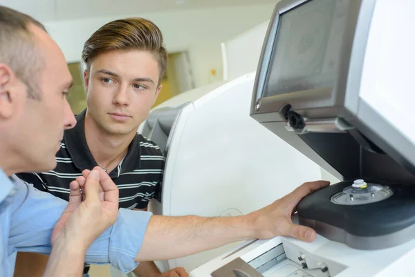 Optiker Erklärt Jungem Mann Maschine — Stockfoto