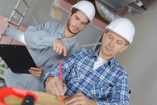 Jonge Timmerman Meewerkende Senior Meten Een Houten Plank — Stockfoto