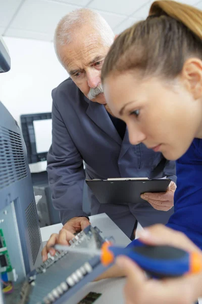 Kvinnliga Elektriker Holding Skruvmejsel Och Undersöka Apparaten — Stockfoto