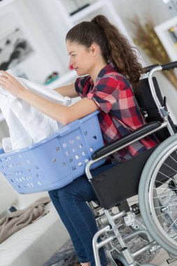 girl on wheelchair folding clothes clipart