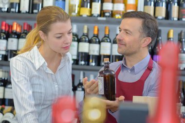wine shop worker selling a bottle of alcoholic beverage clipart