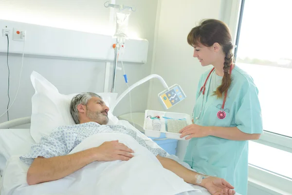 Paciente Masculino Acostado Una Cama Hospital Mientras Enfermera Revisa — Foto de Stock