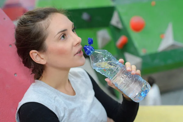 美丽的健身妇女饮水从瓶低键 — 图库照片