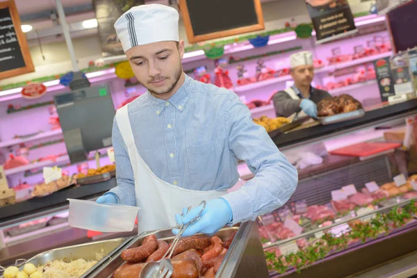 Mannelijke Winkelbediende Die Gekookte Worsten — Stockfoto