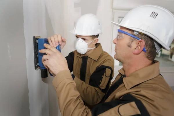 Dos Constructores Puliendo Una Pared Con Papel Lija — Foto de Stock