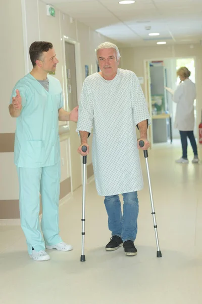 Senior Man Walking Crutches Hospital Corridor — Stock Photo, Image