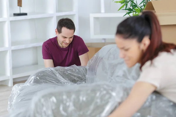 Pareja Cubriendo Sofá Con Plástico — Foto de Stock