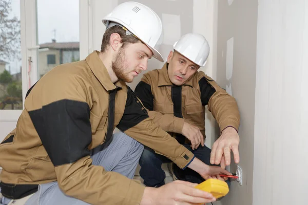 Byggare Med Gul Multimeter För Att Kalibrera Hus — Stockfoto