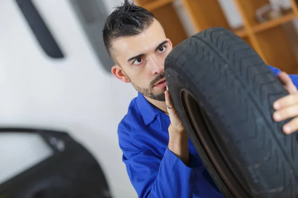 Mecánico Masculino Comprobando Neumático Coche Nuevo — Foto de Stock