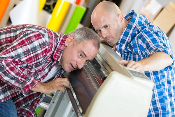 Deux Travailleurs Joyeux Positifs Travaillant Sur Une Machine — Photo