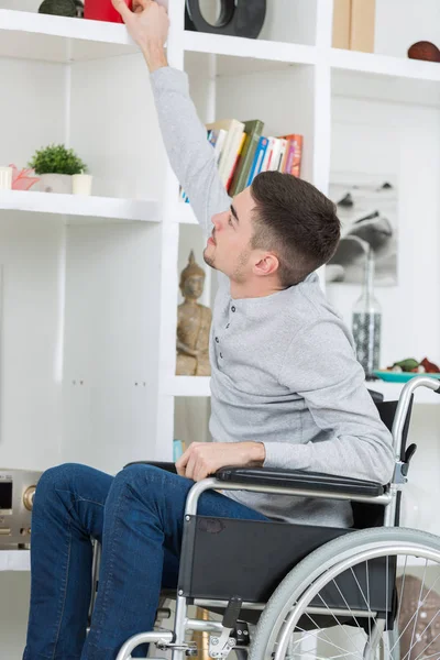 Jeune Homme Handicapé Tendre Main Pour Livre Étagère — Photo