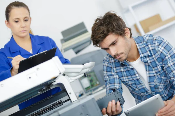 Jovem Técnico Sexo Masculino Usando Tablet Para Reparar Fotocopiadora — Fotografia de Stock