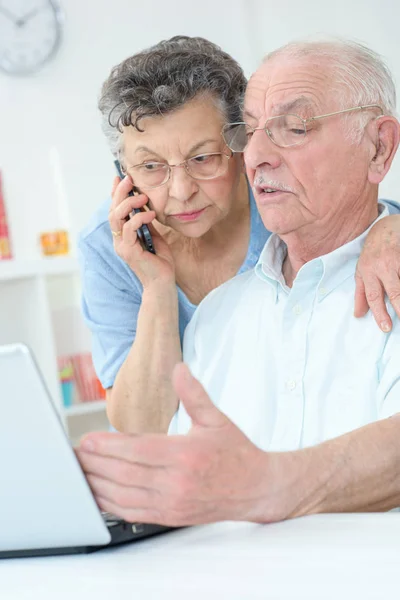 Ηλικιωμένο Ζευγάρι Χρησιμοποιώντας Φορητό Υπολογιστή Γυναίκα Στο Τηλέφωνο — Φωτογραφία Αρχείου